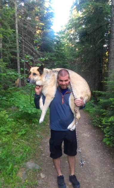 Man carrying dog on shoulders on a trail in Lutsen, MN
