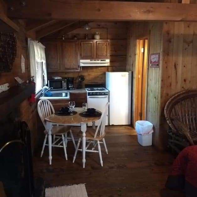 inside of cabin with table and kitchen- dog-friendly cabin in Broken Bow
