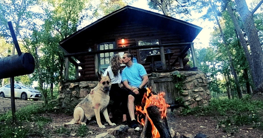 two people and a dog in front of a cabin in Broken Bow Oklahoma