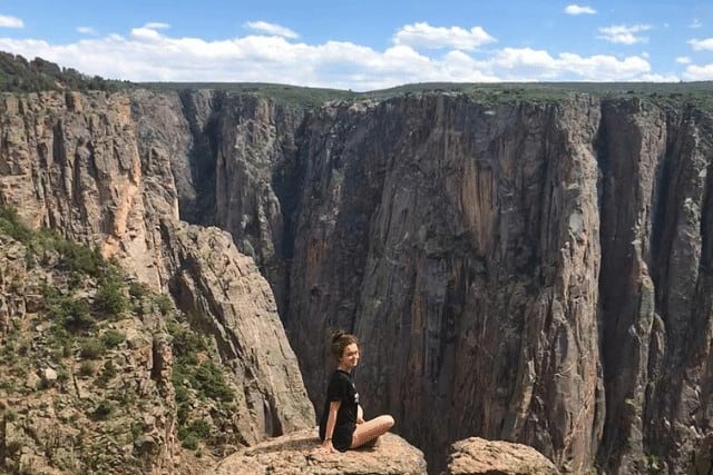Black Canyon of Gunnison National Park. 5 hours from Denver CO. Girl sitting at overlook. 