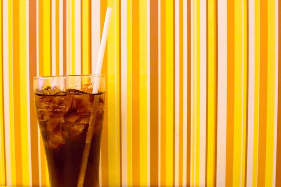 what is the world of coca cola museum- glass of coca cola in front of a yellow striped wall