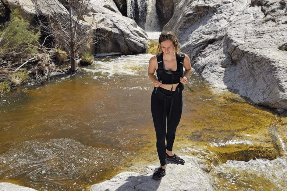 Girl on a day hike in front of a desert waterfall wearing keen whisper sandals.