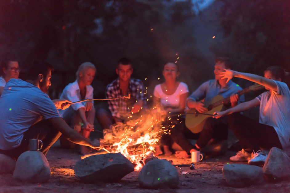 friends sitting around a bonfire while camping