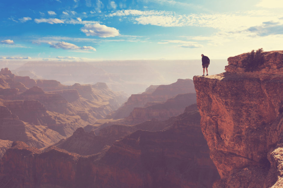 Man standing close to the edge of the Grand Canyon. 