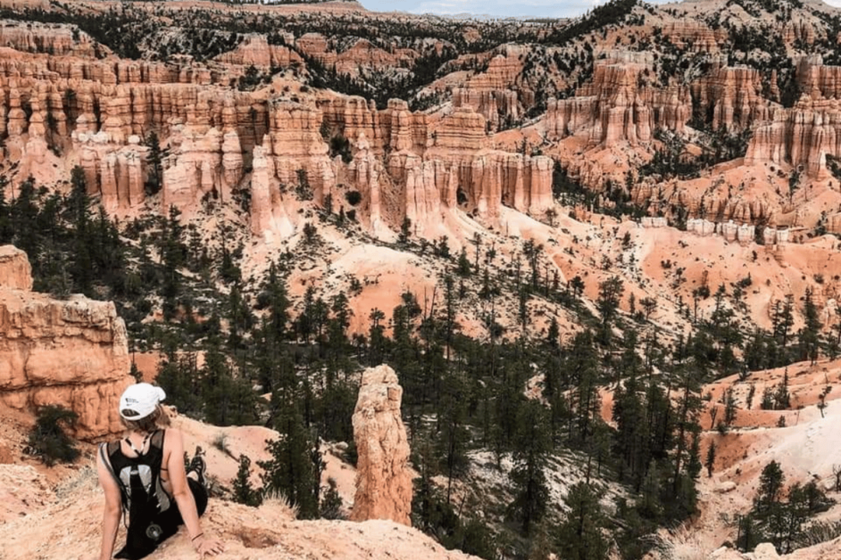 Girl sitting on a trail in Bryce Canyon with a view of Hoodoos- Places to visit in the USA before you die.