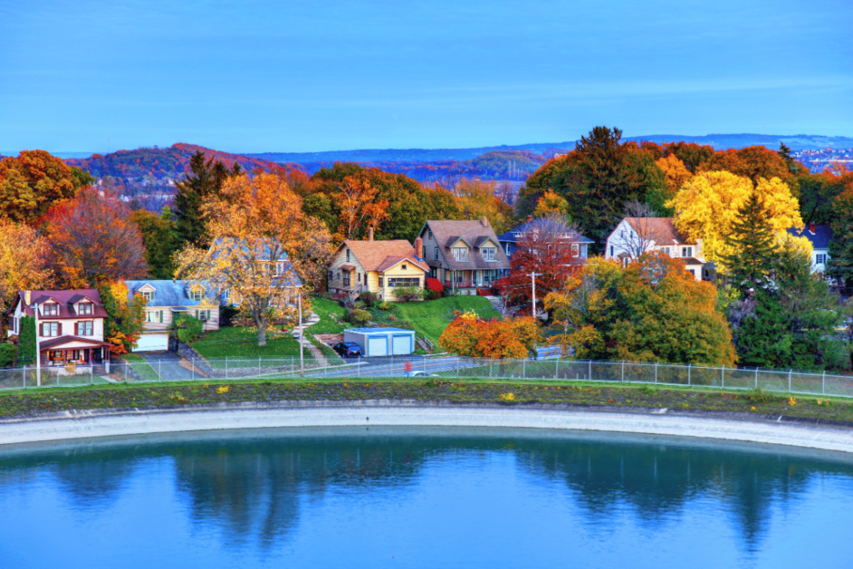 neighborhood in syracuse with fall foliage and a lake. 