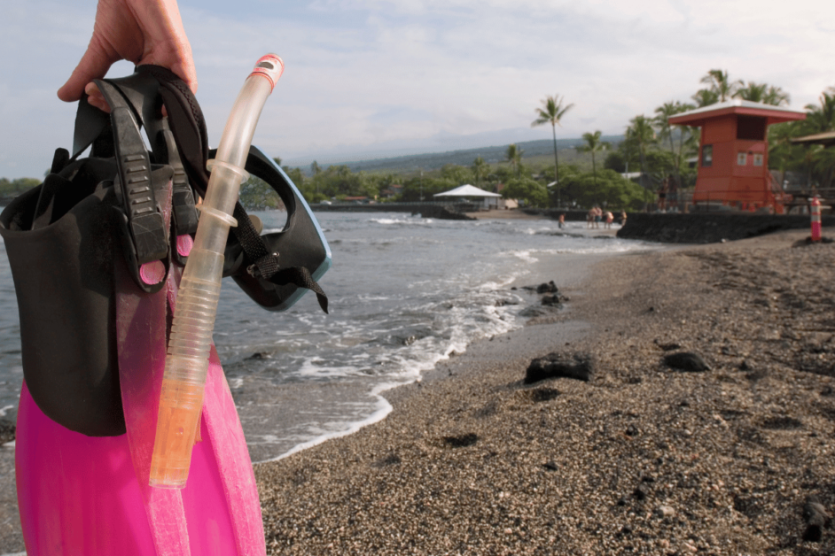 pink flippers on a black sand beach on the big island. 