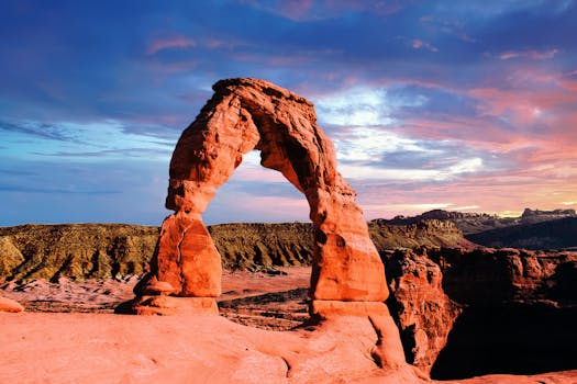 Stunning view of Delicate Arch in Arches National Park, captured at sunset with vivid colors and dramatic skies.