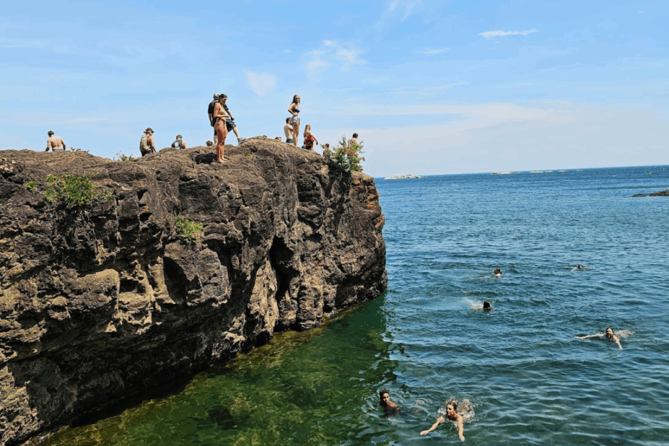 people jumping at Black Rock beach in marquette michigan.